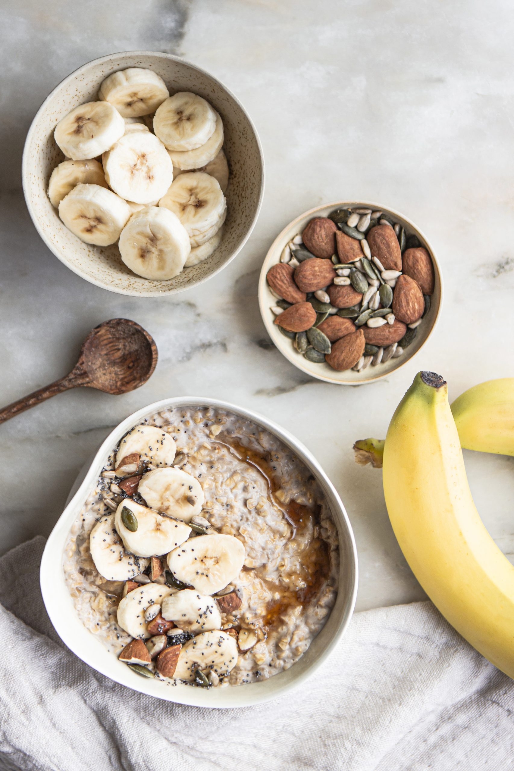 Banana Porridge aux flocons d’avoine, rondelles de bananes fraîches et mélange graines de courge, amande, tournesol, pavot au sirop d’érable